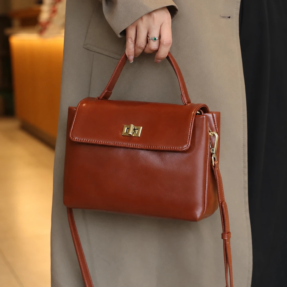 The Harlowe Satchel in coffee oil-wax cowhide, carried by the top handle — Maison Harlowe