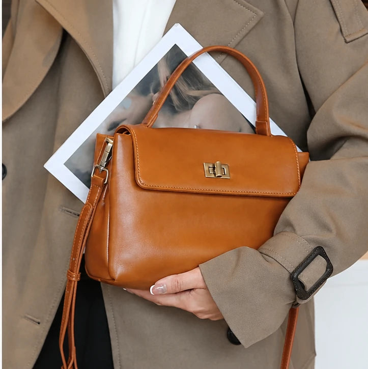 The Harlowe Satchel in brown oil-wax cowhide, worn with the shoulder strap — Maison Harlowe
