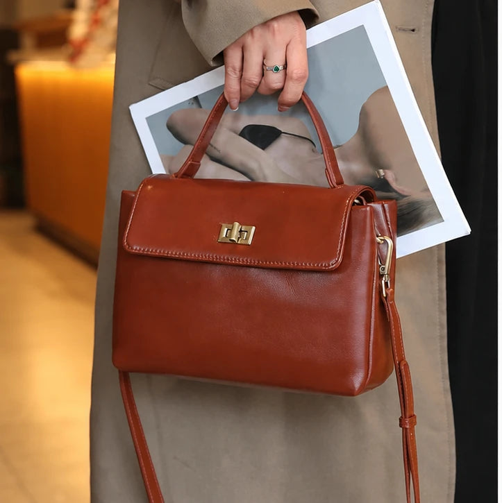 The Harlowe Satchel in brown oil-wax cowhide, carried by the top handle — Maison Harlowe